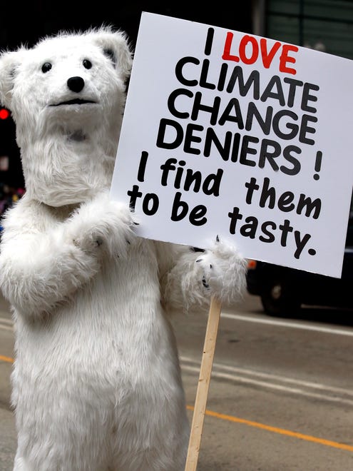 A demonstrator holds a sign during "100 Days of Failure" protest and march on April 29, 2016, in Chicago. Thousands of people across the U.S. are marking President Donald Trump's hundredth day in office by marching in protest of his environmental policies.