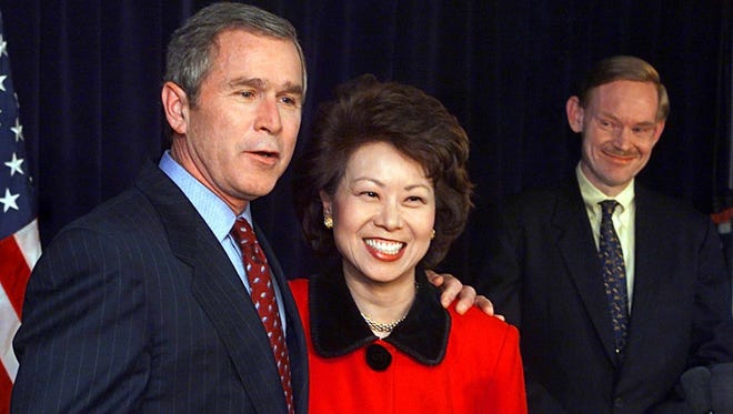 George W. Bush embraces Elaine Chao, his secretary of Labor nominee, alongside trade representative nominee Robert Zoellick during a news conference Jan. 11, 2001, in Washington.