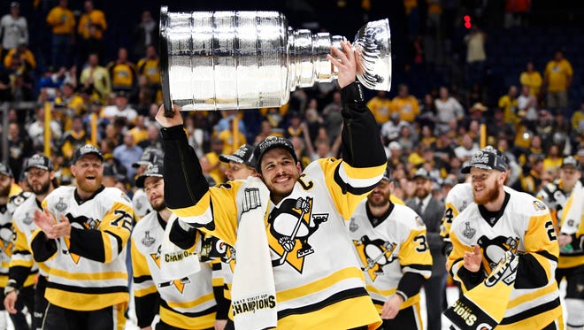 Game 6: Pittsburgh Penguins captain Sidney Crosby (87) hoists the Stanley Cup after the Penguins won Game 6 over the Predators in Nashville, 2-0.