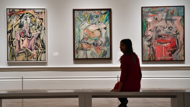 LONDON, ENGLAND - SEPTEMBER 20: A member of staff poses next to paintings by Dutch American artist Willem de Kooning entitled 'Woman' (L), 'Woman II' (C) and 'Woman as Landscape' (R) at the Royal Academy of Arts on September 20, 2016 in London, England. Forming part of the 'Abstract Expressionism' exhibition, they are due to be displayed from September 24, 2016 to January 2, 2017.  (Photo by Carl Court/Getty Images)