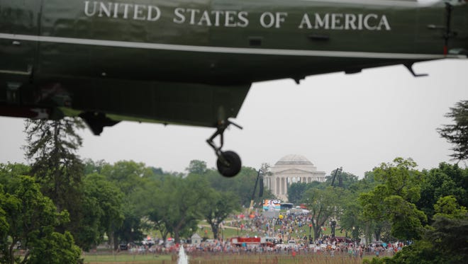 A Climate Change rally on the National Mall is seen in the distance as Marine One helicopter, with President Donald Trump aboard, lifts off from South Lawn of the White House in Washington. Thousands of people gathered across the country to march in protest of Trump's environmental policies, which have included rolling back restrictions on mining, oil drilling and greenhouse gas emissions at coal-fired power plants.