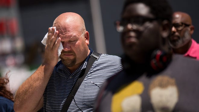 A man wipes sweat from his face in Midtown Manhattan, July 19, 2017 in New York City. The National Weather Service had issued a heat advisory with temperatures expected to be in the 90s with high humidity.