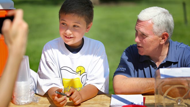 Indiana Governor Mike Pence chats with young entrepreneur Nathan Walsh, 7, during Lemonade Day at the Statehouse, Friday, May 30, 2014.  Nathan told the governor he is good in math, and that some people say he could help with the budget.