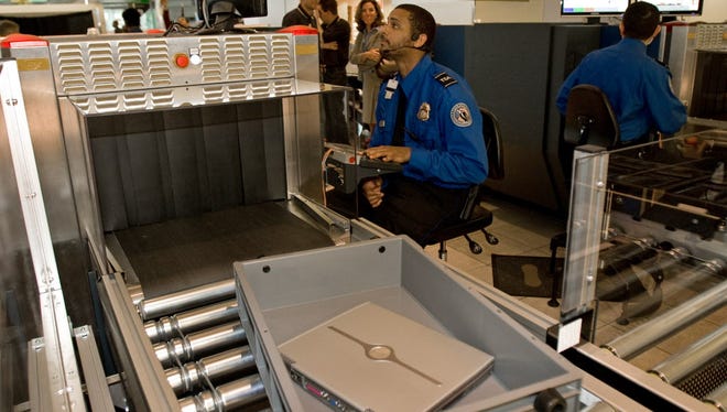 A Transportation Security Administration officer reads the X-ray of a laptop computer that rides in a new style bin for carry-ons at Baltimore-Washington International Airport's security screening checkpoint B in the Southwest terminal on April 28, 2008.