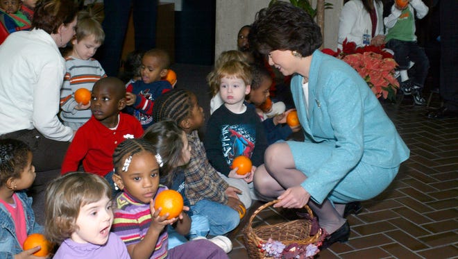Chao gives oranges to children in the Department of Labor Daycare Center after the annual lighting of the Capitol’s Christmas Tree.