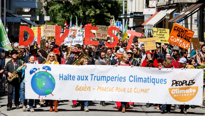 Protesters hold placards reading, 'Stop climatic Trumperies' during the World Climate March in Geneva, Switzerland.