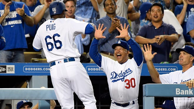 Puig celebrates a home run against the Giants with manager Dave Roberts.