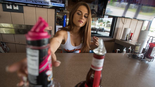 Mariah Materiale, 22, of Cape Coral,  prepares her work area in the outside bar of Hooters Monday afternoon. Materials will be heading to Las Vegas to represent her Hooters in the 21st Annual Hooters International Pageant.