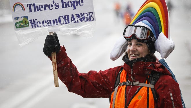 Meteorologist Lis Cohen of Denver holds a sign while cheering on protesters at the People's Climate March in Denver.