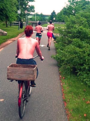 Chelsea Covington of the Eastern Shore of Maryland, who advocates for equality for shirtless men and women, rides her bike bare chested on the Schuylkill River Trail in Philadelphia.