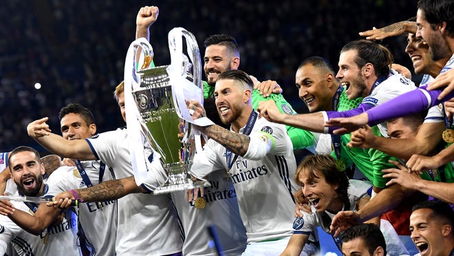 Real Madrid's Sergio Ramos lifts the trophy while celebrating with his teammates winning the UEFA Champions League final.
