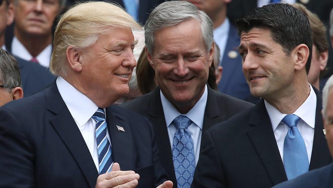 President Donald Trump (left) stands with House Speaker Paul Ryan (R-Wis.) (right) and Freedom Caucus Chairman Mark Meadows (R-N.C.), after Republicans passed legislation aimed at repealing and replacing Obamacare during an event in the Rose Garden at the White House on May 4.