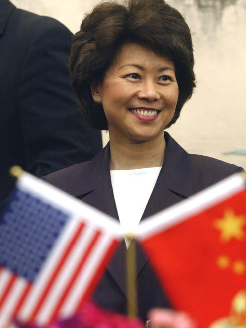 Elaine Chao stands near Chinese and U.S. flags in Beijing on June 21, 2004.