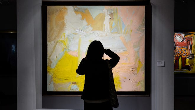 A visitor takes a photo of Willem de Kooning's 'Pastorale', with Jean-Michel Basquiat's 'Sugar Ray Robinson' (R) in the background, at "The Loaded Brush" display by auction house Christie's in Hong Kong on November 23, 2016.
Auction house Christie's is holding its first ever sale of Western art masterpieces in Hong Kong this week, in response to a surge in interest from wealthy Asian collectors.    / AFP / Anthony WALLACE / RESTRICTED TO EDITORIAL USE - MANDATORY MENTION OF THE ARTIST UPON PUBLICATION - TO ILLUSTRATE THE EVENT AS SPECIFIED IN THE CAPTION        (Photo credit should read ANTHONY WALLACE/AFP/Getty Images)