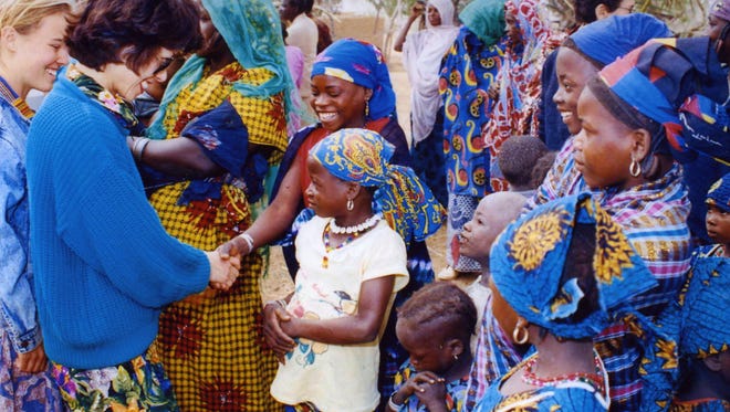 Chao visits Peace Corps volunteers and village children in Niger while serving as director of the Peace Corps.