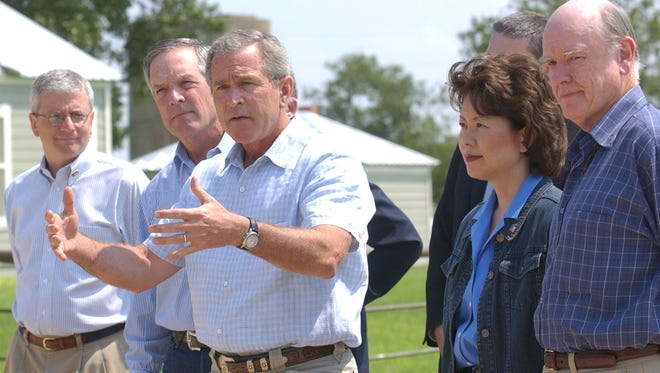 President George W. Bush gestures as he speaks with the news media while OMB Director Joshua Bolten, Commerce Secretary Don Evans, Labor Secretary Elaine Chao and Treasury Secretary John Snow are at Bush's ranch Aug. 13, 2003, in Crawford, Texas.