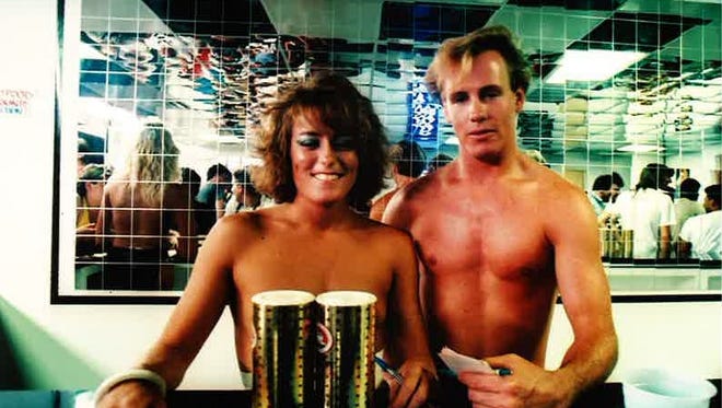 A waitress and "token male waiter" pose on opening day at Debbie Duz Donuts, July 29, 1989.