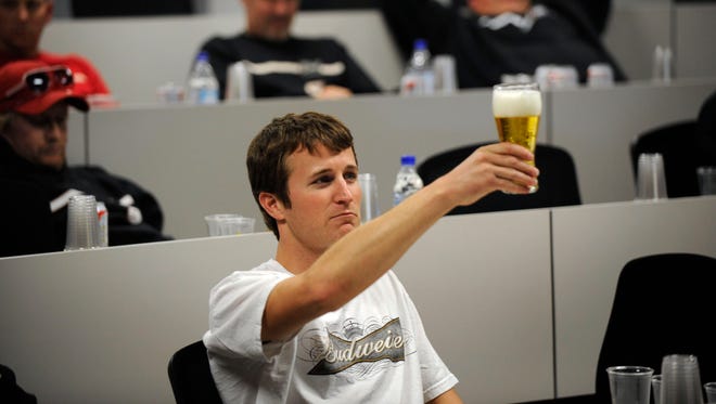 Kasey Kahne raises a Bud to the light to check its coloring during a beer tasting at Richard Petty Motorsports in April 2009. Budwieser sponsored Kane from 2008 through 2010.