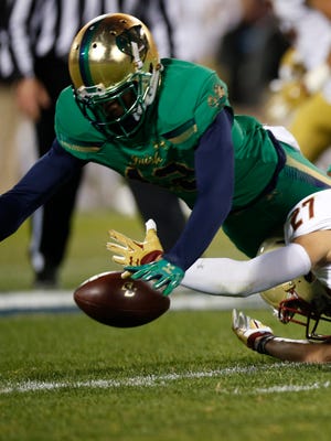 Boston College Eagles back Justin Simmons (27) fumbles the ball while defended by Notre Dame Fighting Irish cornerback Devin Butler (12) during the first quarter at Fenway Park.