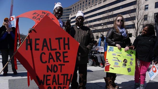 Health care activists hold placards during a rally at Freedom Plaza on March 23, 2017, in Washington.