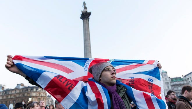 A man holds a Union jack flag a during a vigil in Trafalgar Square in central London on March 23, 2017 in solidarity with the victims of the March 22 terror attack at the British Parliament and on Westminster Bridge.