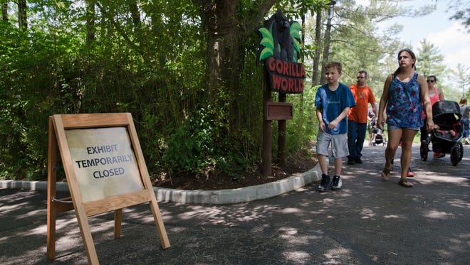 Visitors pass outside the shuttered Gorilla World exhibit at the Cincinnati Zoo & Botanical Garden, Sunday, May 29, 2016, in Cincinnati. On Saturday, a special zoo response team shot and killed Harambe, a 17-year-old gorilla, that grabbed and dragged a 4-year-old boy who fell into the gorilla exhibit moat. Authorities said the boy is expected to recover. He was taken to Cincinnati Children's Hospital Medical Center.