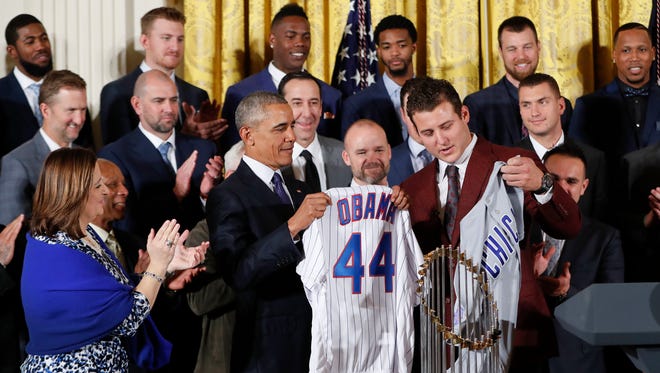 President Obama holds up a personalized Cubs jersey presented by the Cubs' No. 44, Anthony Rizzo.