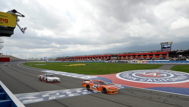 Kyle Larson (42) takes the checkered flag ahead of Joey Logano to win the NASCAR Xfnity Series race at Auto Club Speedway on March 25, 2017.