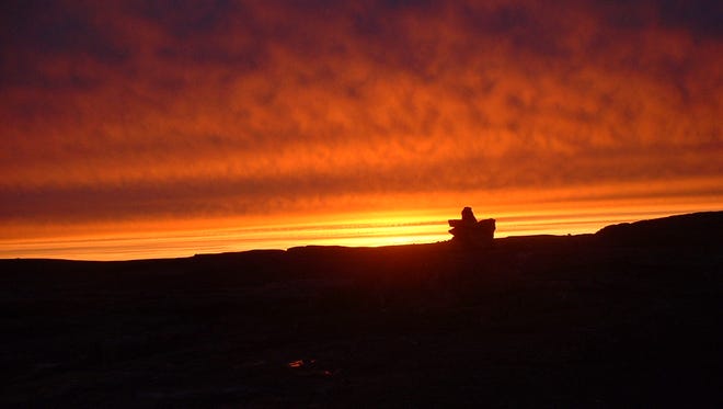 The Inuit-made inuksuk stands its position on the horizon.