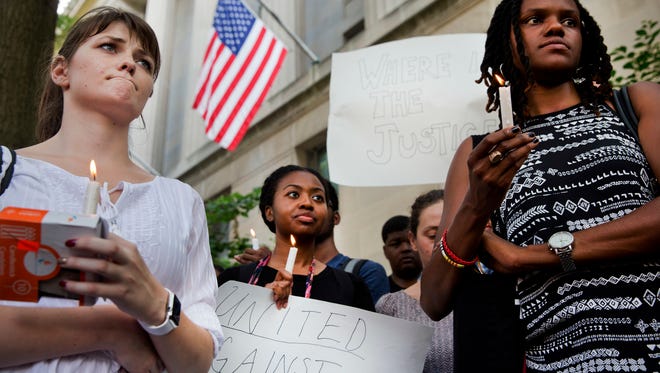 Ashley Wilson, 21, left, a student at George Washington University, Janay Richmond and Jeanne Isler, right, both with the National Committee for Responsive Philanthropy, rally in support of the 'Black Lives Matter' movement in front of the Department of Justice in Washington on Friday.