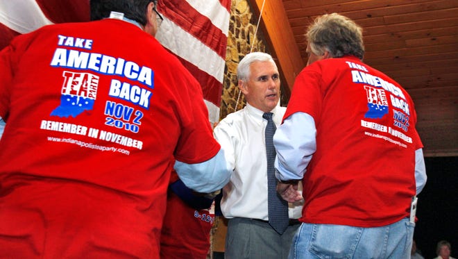 Peter Recchio, co-founder of Tea-MAC, the Tea Party of Michiana Action Coalition, left, and Rick Barr, right, shake hands with Indiana Congressman Mike Pence after his speech at the Indianapolis Tea Party get-out-the-vote rally held in Hummel Park in Plainfield on Friday night, October 15, 2010. Charlie Nye / The Star.