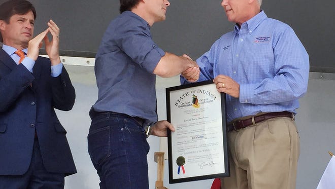 Indiana Gov. Mike Pence presents NASCAR driver Jeff Gordon with the Sagamore of the Wabash as Indianapolis Motor Speedway President Doug Boles (left) looks on during honorary presentations at Scamahorn Park in Pittsboro, Ind. on Jeff Gordon Day, Thursday, July 23, 2015.