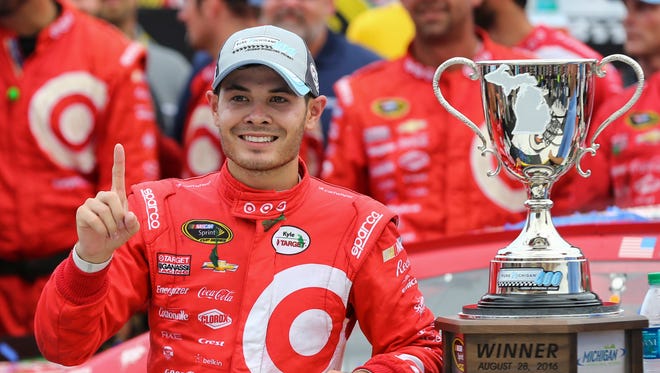 Kyle Larson poses with the Pure Michigan 400 trophy after scoring his first career Sprint Cup Series victory on Aug. 28, 2016.