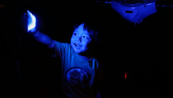 A Filipino boy plays with available light from an amusement park ride during Earth Hour in Pasay city, south of Manila, Philippines, on March 19, 2016. Earth Hour takes place worldwide at 8.30 p.m. local time and is a global call to turn off lights for 60 minutes to raise awareness of the danger of global climate change.
