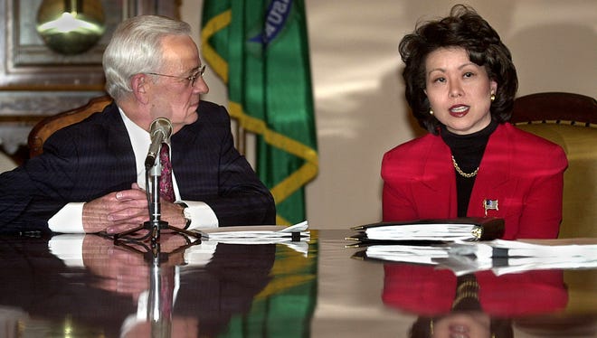 Secretary of Treasury Paul O'Neill listens to Elaine Chao make brief remarks to the news media Jan. 17, 2002, during a Working Group on Retirement Security Protection meeting at the Treasury Department.