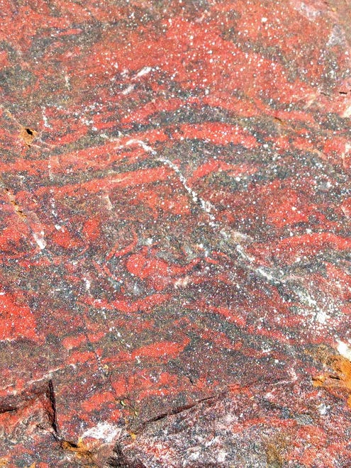 Layered haematite (red) and quartz (grey) rock from the 480 million-year-old Løkken hydrothermal vent deposit, in Norway. This rock also contains filamentous microfossils composed of haematite and therefore, it is a younger analogue for ancient habitats on early Earth and possibly elsewhere in the Solar System.
