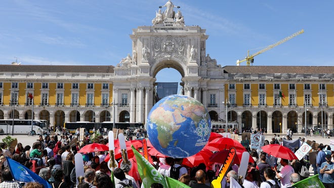 People attend a World Climate March in Lisbon, Portugal on April 29, 2017.