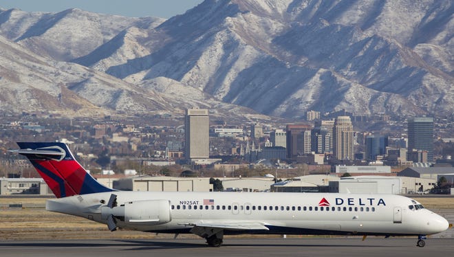 Downtown Salt Lake City and mountains provide a stunning backdrop as a Delta Air Lines Boeing 717 comes to a stop at Salt Lake City International Airport on Nov. 25, 2016.