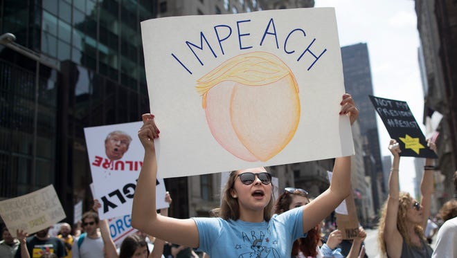 Deonstrators march across Fifth Avenue during "100 Days of Failure" protest and march in New York.  Thousands of people across the U.S. are marking President Donald Trump's hundredth day in office by marching in protest of his environmental policies.