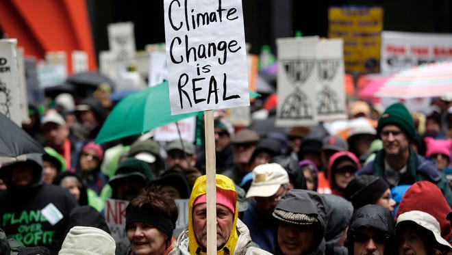Demonstrators holds signs during the  People's Climate March on April 29, 2017 in Chicago.