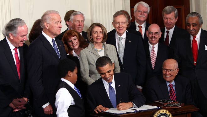 President Barack Obama signs the Affordable Care Act during a ceremony with fellow Democrats in the East Room of the White House on March 23, 2010 in Washington, D.C.