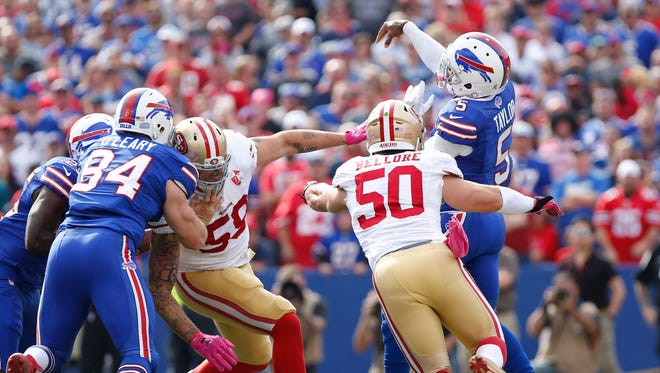 Buffalo Bills quarterback Tyrod Taylor (5) is hit by San Francisco 49ers inside linebacker Nick Bellore (50) as he throws a pass during the first quarter at New Era Field.