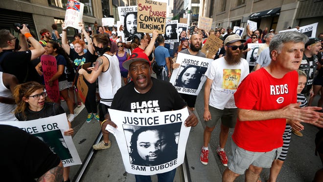 Walter Smith, center, and other demonstrators chant on Walnut Street during a Countdown to Conviction Coalition rally and march for justice for Sam DuBose Saturday, July 22, 2017. Sam DuBose was unarmed when he was shot and killed during a traffic stop by former University of Cincinnati police officer Ray Tensing, July 19, 2015. Tensing was tried two times, both trials ended in hung juries. Hamilton County Prosecutor Joe Deters that he will not seek a third trial for Tensing