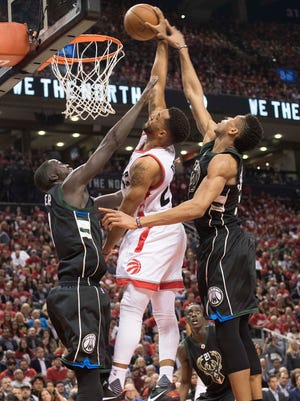 Toronto Raptors guard Norman Powell dunks between Milwaukee Bucks forward Giannis Antetokounmpo and Bucks forward Thon Maker during the fourth quarter in game five of the first round of the 2017 NBA Playoffs at Air Canada Centre.
