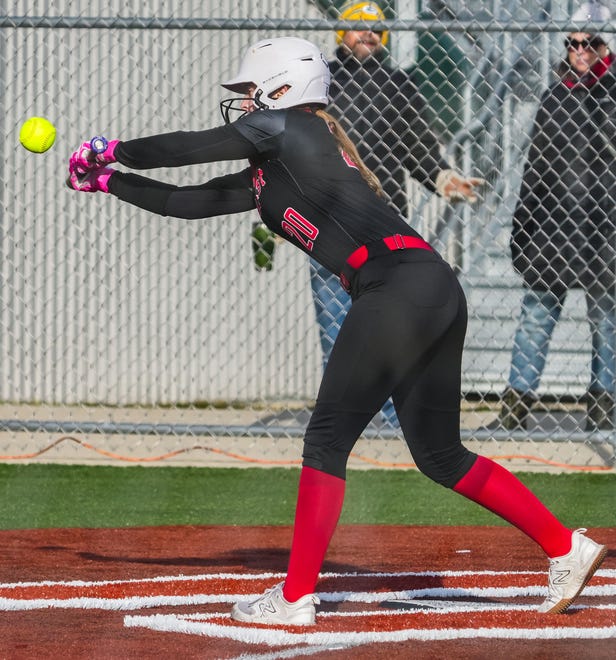 Wauwatosa East's Cassie Krause (20) attempts a bunt during the game at Wauwatosa West, Thursday, March 21, 2024.