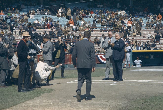 Commisioner of Baseball Bowie Kuhn and American League president Joe Cronin clap at home plate as Brewers president Bud Selig walks up to accept a commemorative baseball during the Brewers' first opening day on April 7, 1970. It was also the season opener for the Brewers. A crowd of 37,237 saw the Brewers fall to the California Angels 12-0.