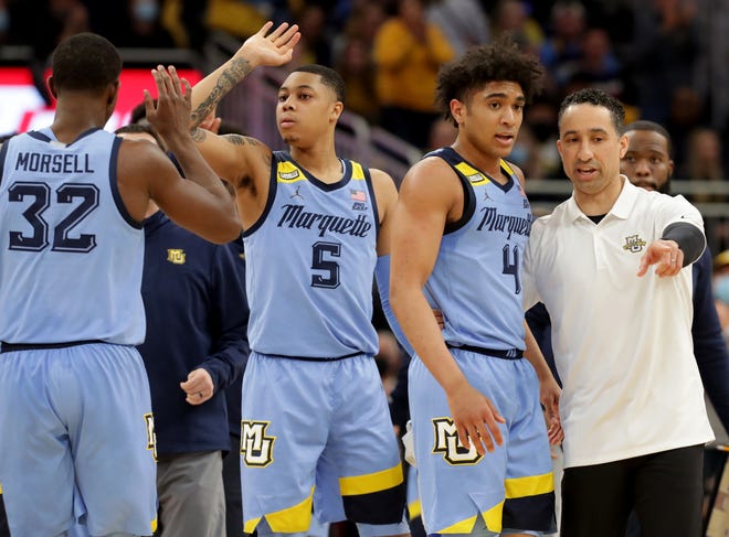 Marquette guard Stevie Mitchell (4) listens to head coach Shaka Smart during the second half of their game Saturday, February 26, 2022 at Fiserv Forum in Milwaukee, Wis. Marquette beat Butler 64-56. In the background are Marquette guard Greg Elliott (5) and guard Darryl Morsell (32).
